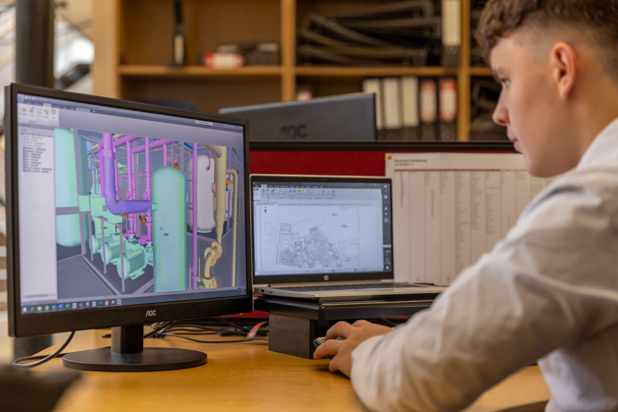 Engineer reviewing a 3D CAD model of plant piping and pumps