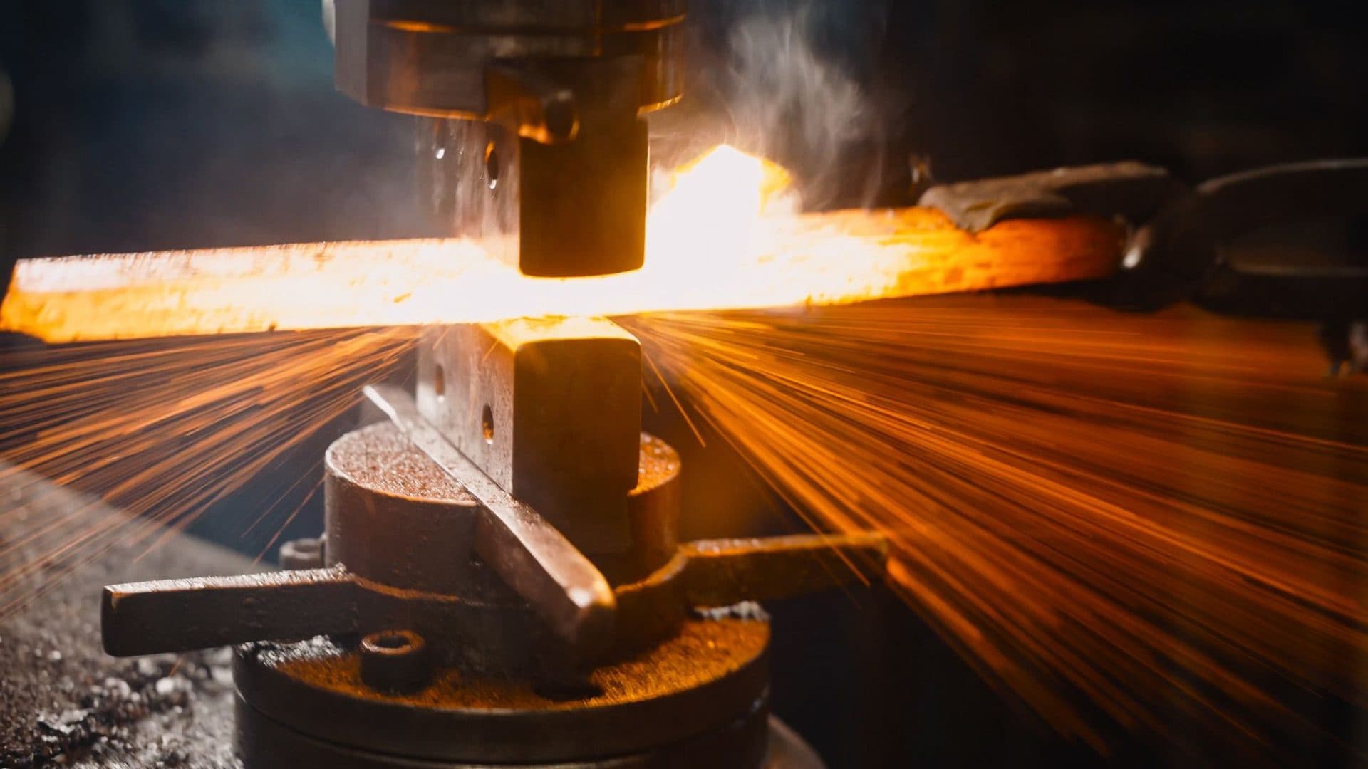 Sparks flying from a hot forging on a press