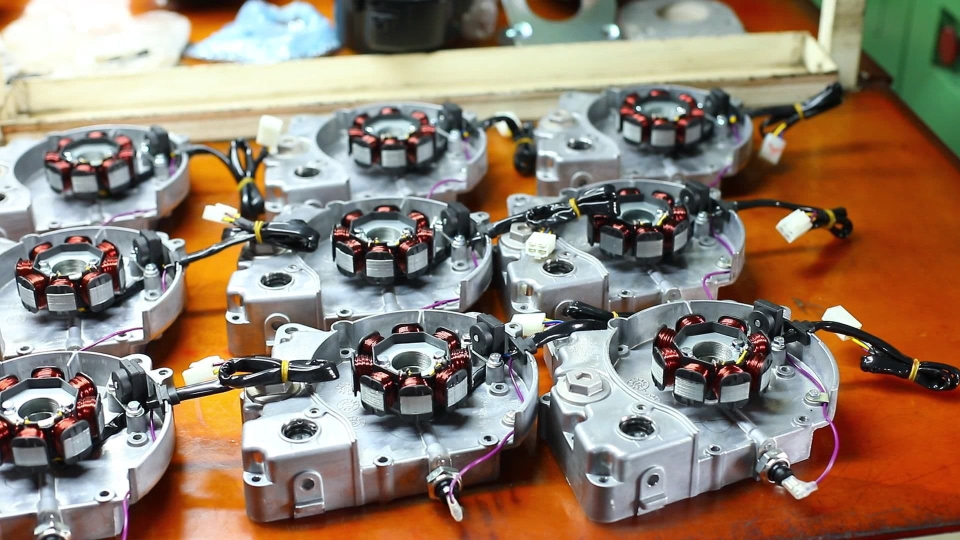 Motor sub-assemblies laid out in rows as kits on a workbench